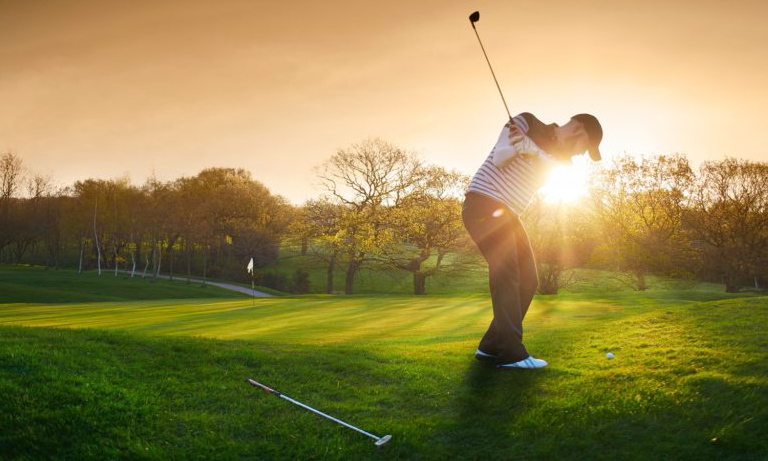 man teeing off on a golf course